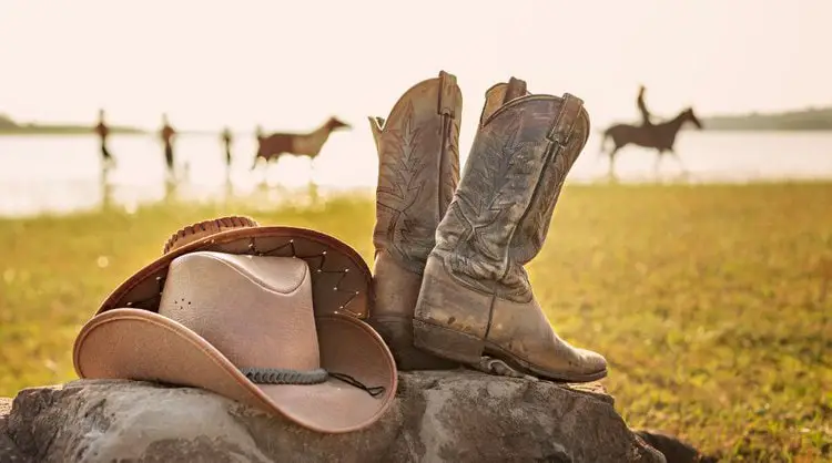 Cowboy boots and cowboy hat on the rock on the ranch