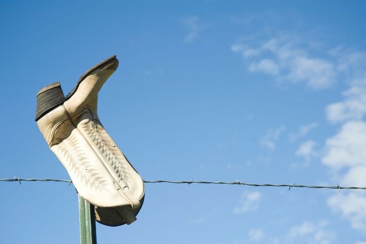 a cowboy boot with the sole is pointing skyward