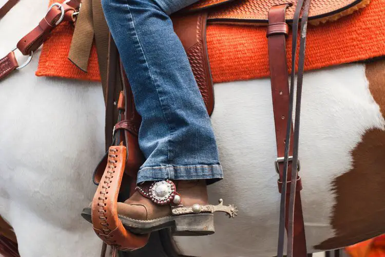 man wearing cowboy boots sitting on the horse