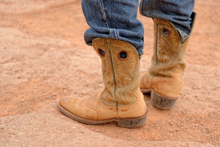 man wears jeans and cowboy boots for ranching