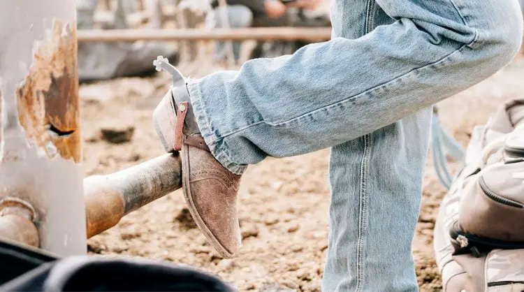 Man wear jeans with cowboy boots stand on the ranch