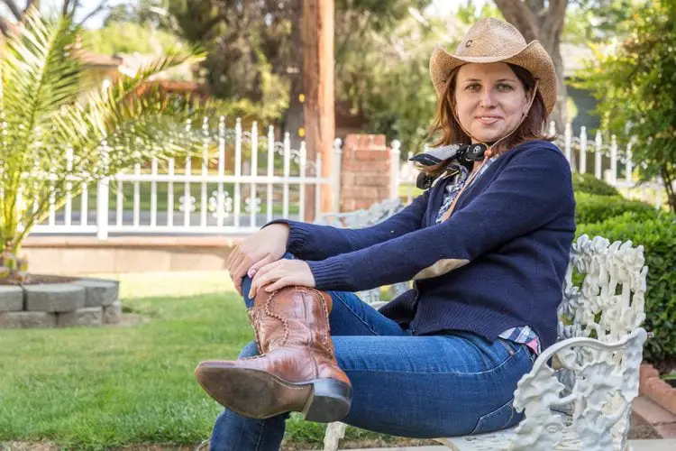 Women wear brown cowboy boots with jeans is sitting on the chair