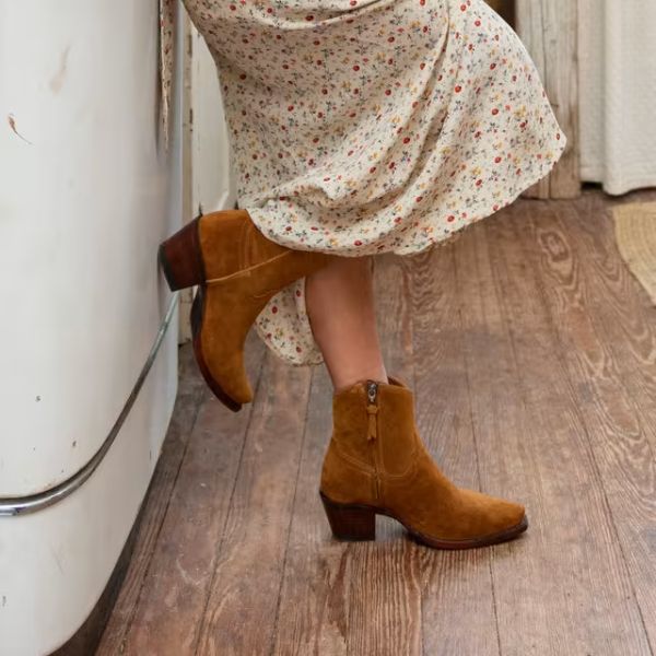 Women wearing The Daisy cowboy boots stand on the wooden floor