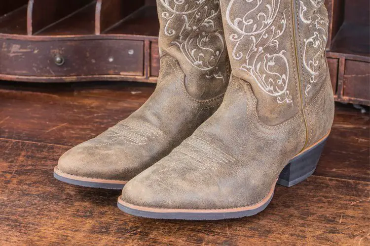 A pair of cowboy boots on the wooden floor