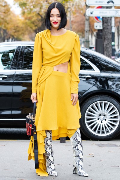 A woman wears yellow dress with snakeskin cowboy boots