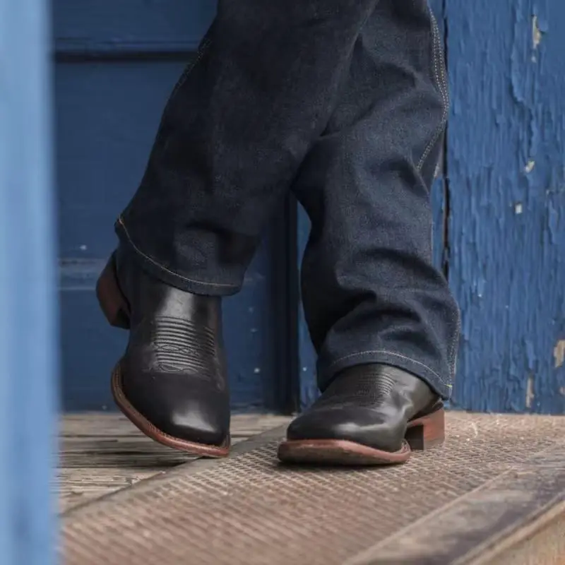 A man wears The Doc square toe boots from Tecovas