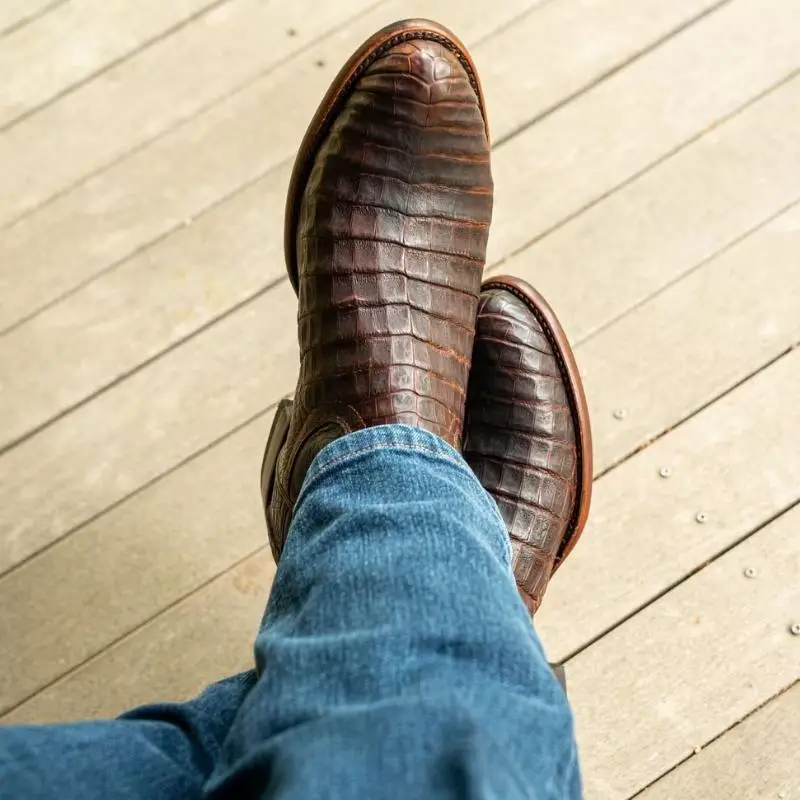 a man wears The Cole caiman belly boots from Tecovas