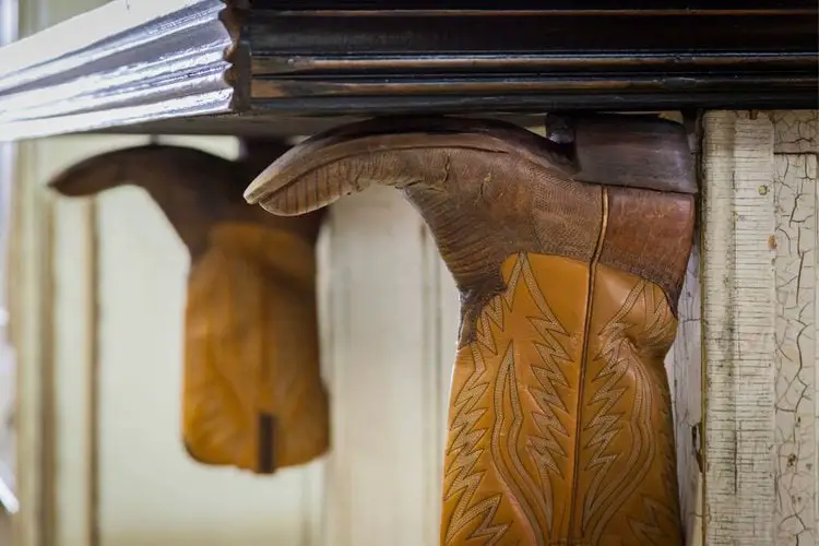 Cowboy boots upside down and attached to a wooden table