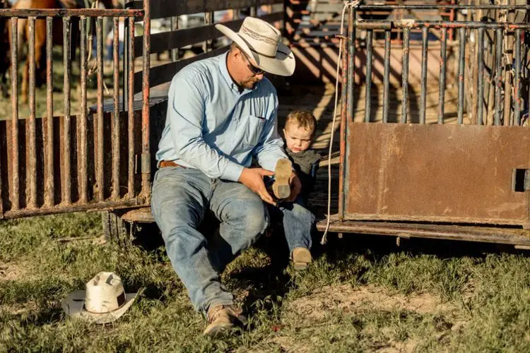 Dad are wearing cowboy boots for son