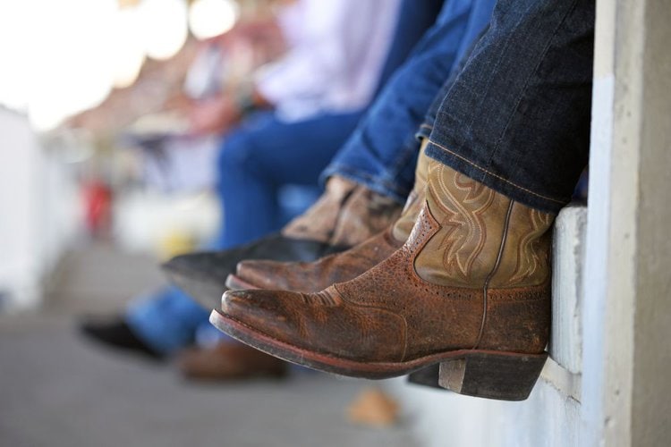Man wear cowboy boots and are sitting