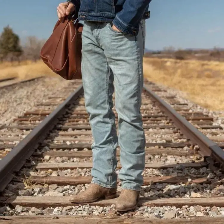 Man wear cowboy boots, jeans, and jeans jackets
