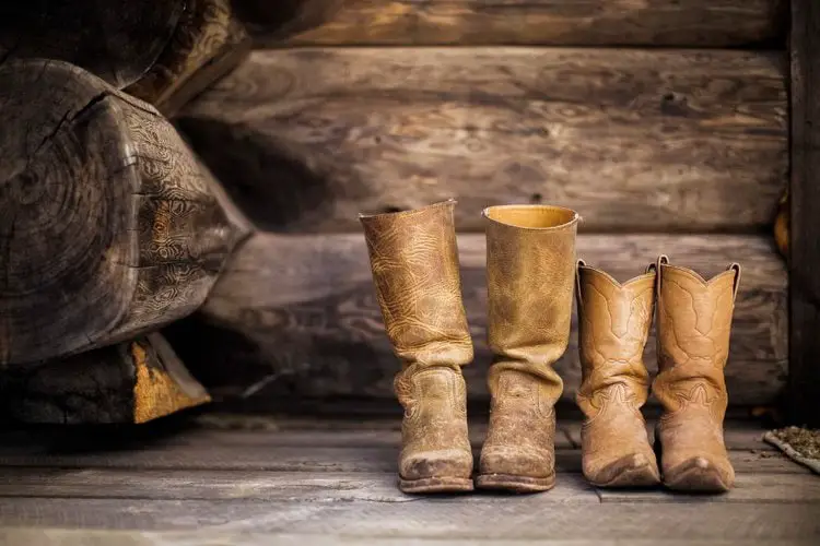 Two pairs of cowboy boots on the wooden floor