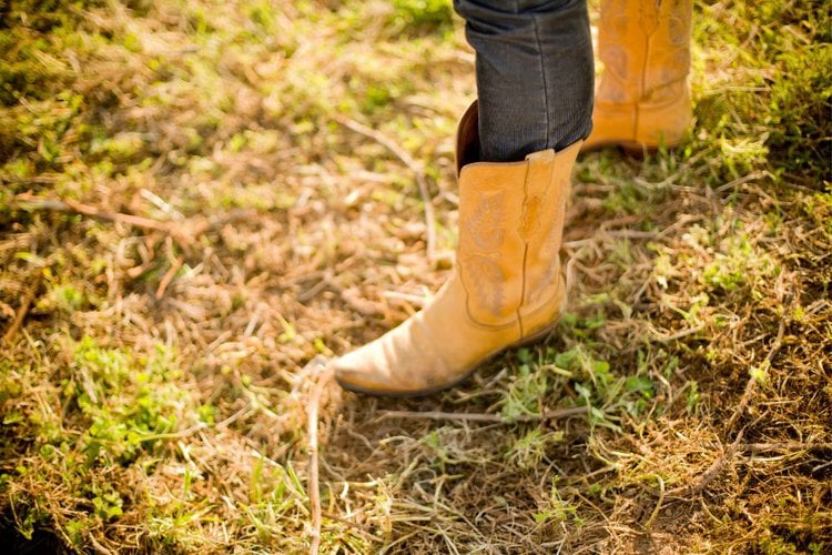 Women wear cowboy boots and are standing on the ground