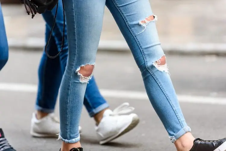 girls wear ripped jeans walking on the street