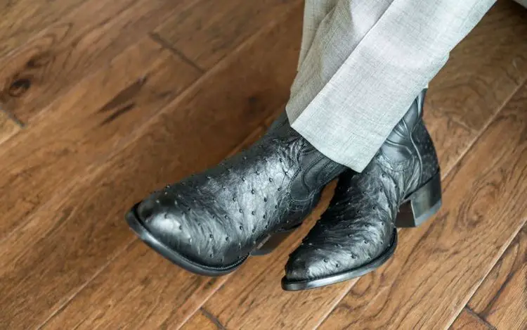 Man wear The Wyatt black ostrich cowboy boots with a suit pants