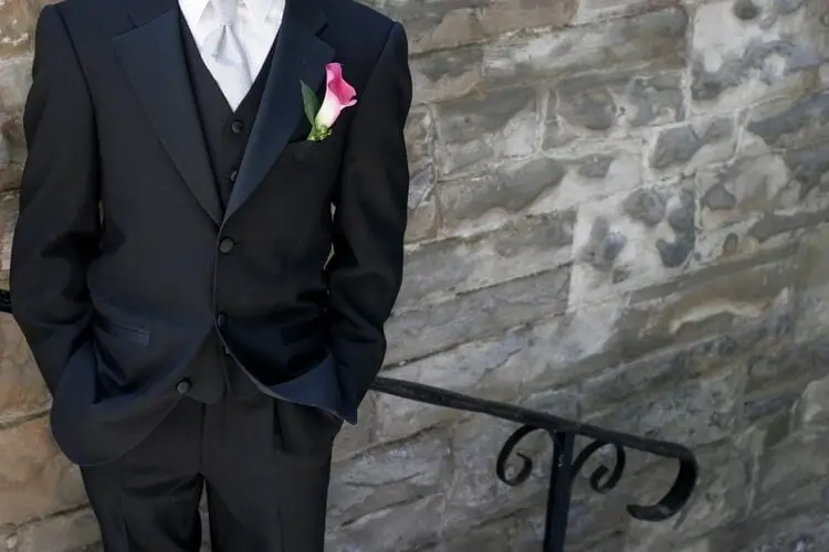 man wears black tuxedo with flower in the pocket