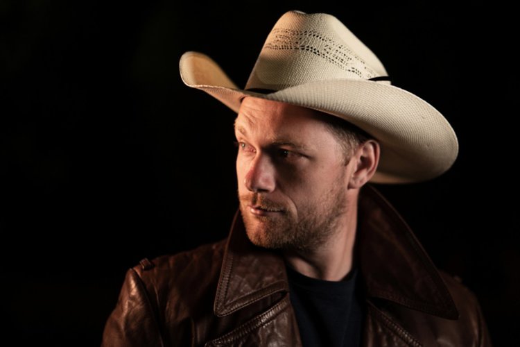 a handsome man wears a straw cowboy hat