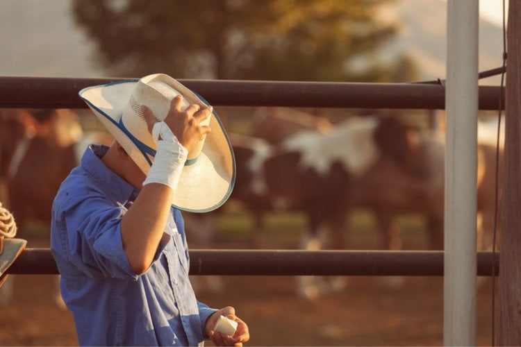 a rancher is holding straw cowboy hat