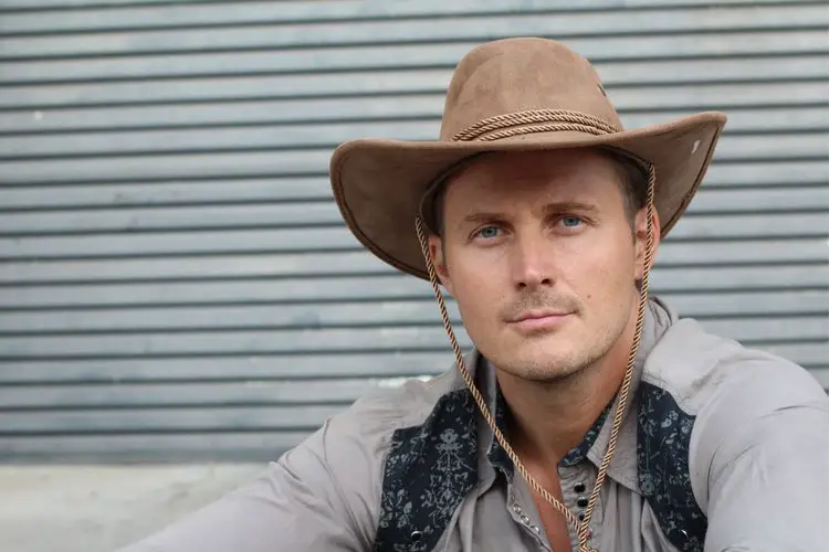 man wears a cowboy hat with stampede string