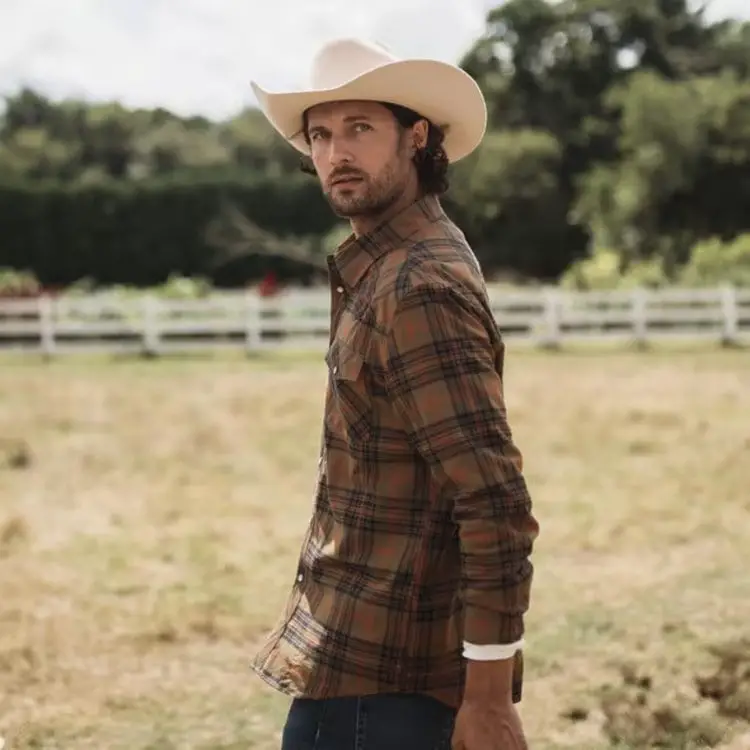 man wears cowboy hat and brushed cotton pearl snap from Tecovas