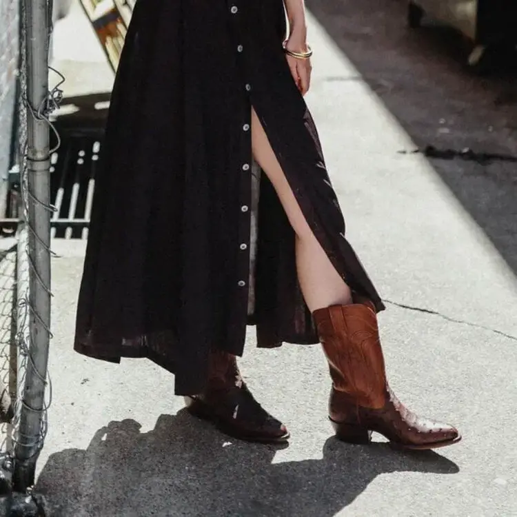 A woman wears maxi dress with The Jessie ostrich cowboy boots