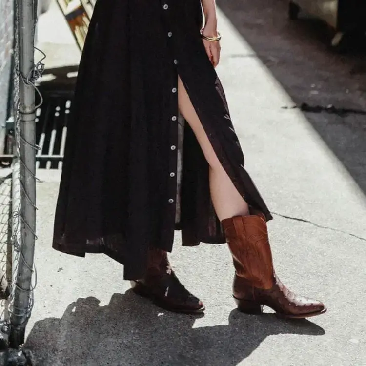 A woman wears maxi dress with ostrich cowboy boots