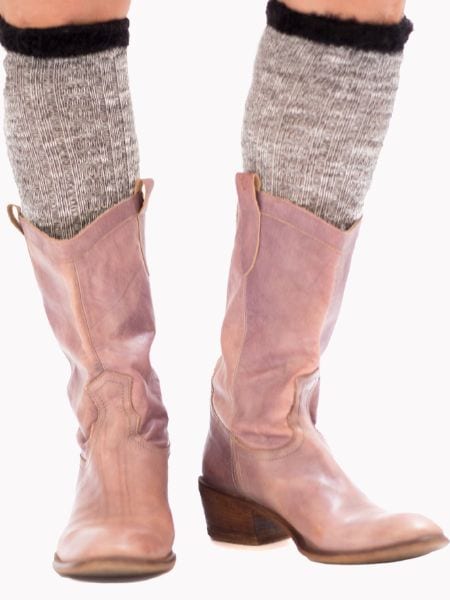 A woman wears socks with cowboy boots