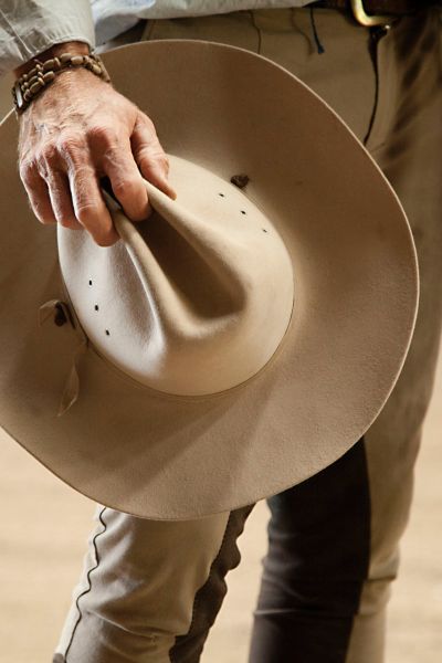 A man holds a cowboy hat in hand