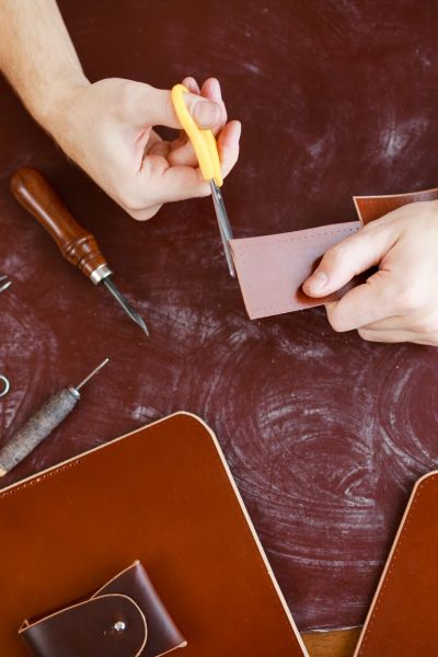 Using a Sharp Pair of Scissors to cut a leather belt