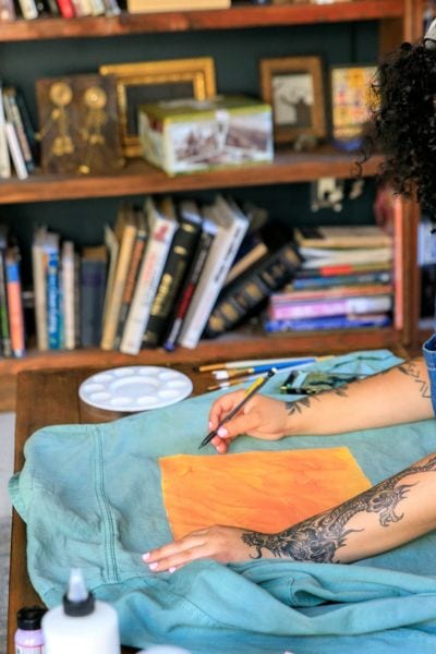 A woman is painting on the denim