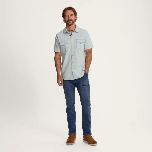 Man wears Denim Short Sleeve Pearl Snap with jeans and cowboy boots