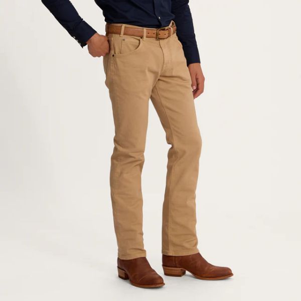 A man wears Men's Everyday Standard Jeans in Sand color