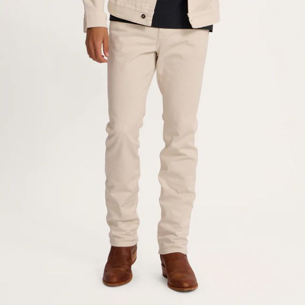 A man wears Men's Everyday Standard Jeans in natural color