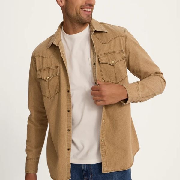 A man wears Tecovas Denim Pearl Snap Shirt as jacket