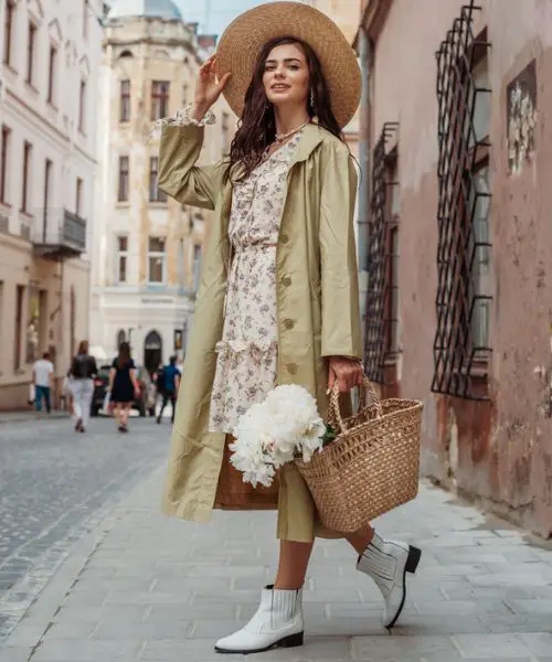 A woman wears boho dress with a blazer and white cowboy boots.