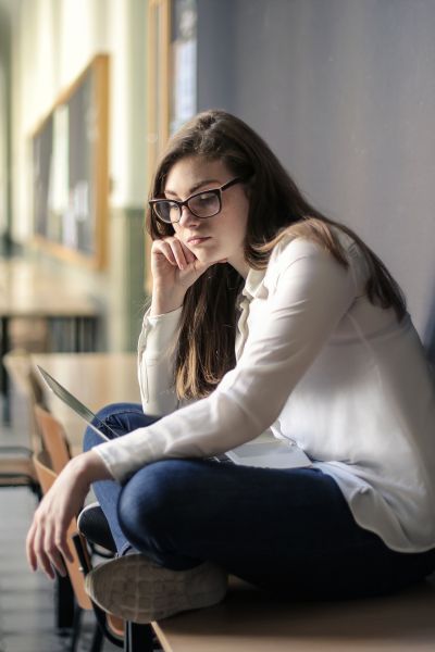 A woman wears jeans and is sitting