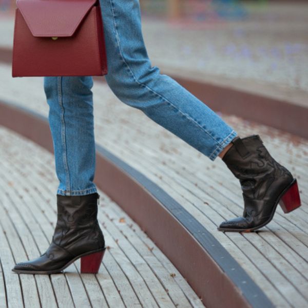 A woman wears jeans with ankle boots with a gap between them