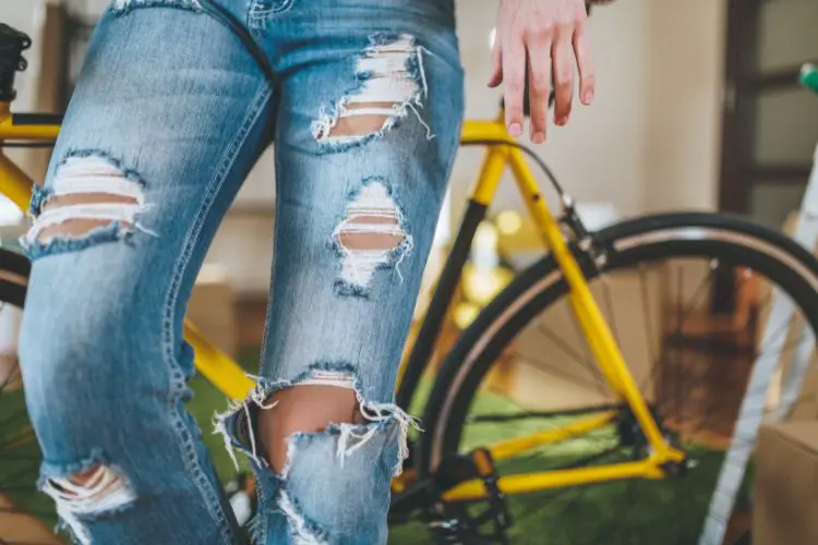 A woman wears ripped jeans