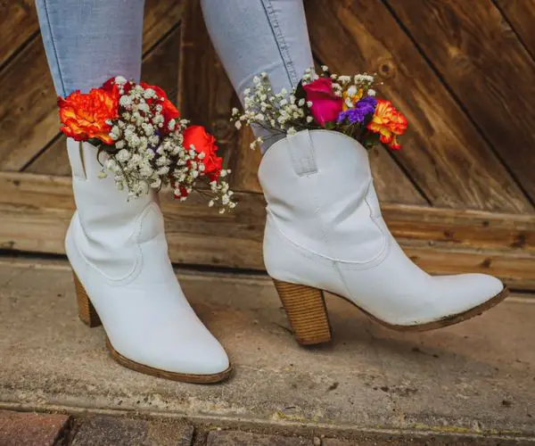 A woman wears skinny jeans with white high heeled cowboy boots