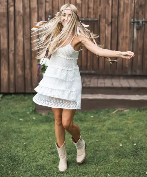 A woman wears white dress with white cowboy boots
