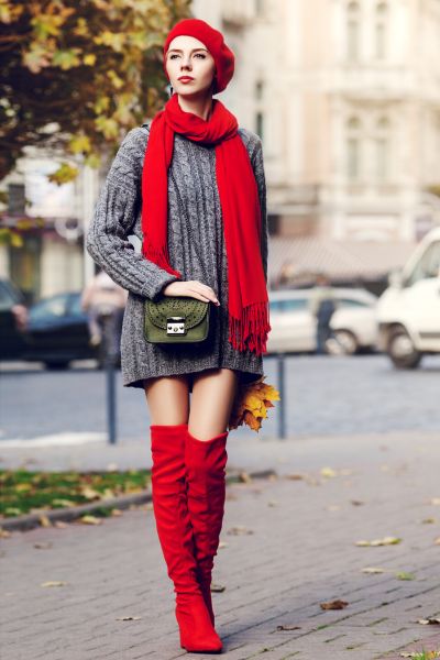 A women wears red over the knee boots with red calf and red wool hat
