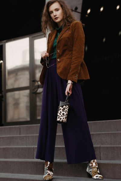 A woman wears blazer with dress pants, cowboy boots