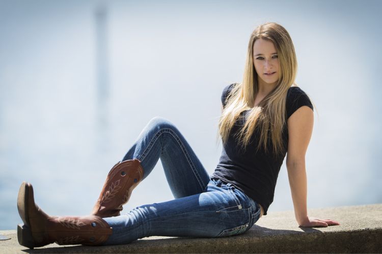 A woman wears cowboy boots, jeans and a simple T shirt