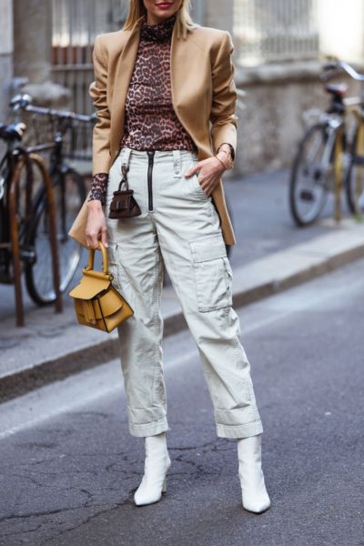 A woman wears cowboy boots with a lot of accessories for street style.