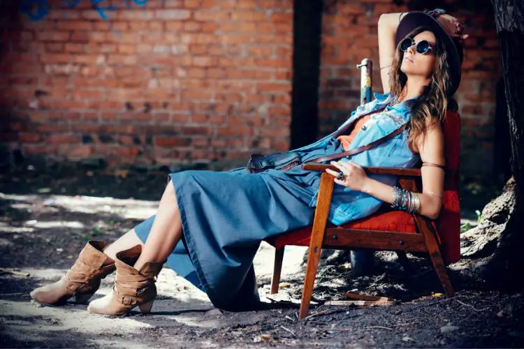 A woman wears denim skirt with cowgirl boots. 