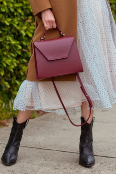 A woman wears dotted midi dress with ankle cowboy boots