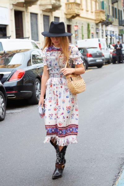 A woman wears dress with cowboy boots