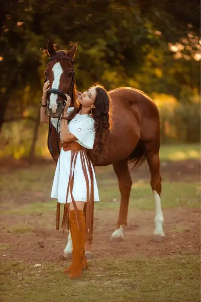 A woman wears dress with over the knee suede cowboy boots