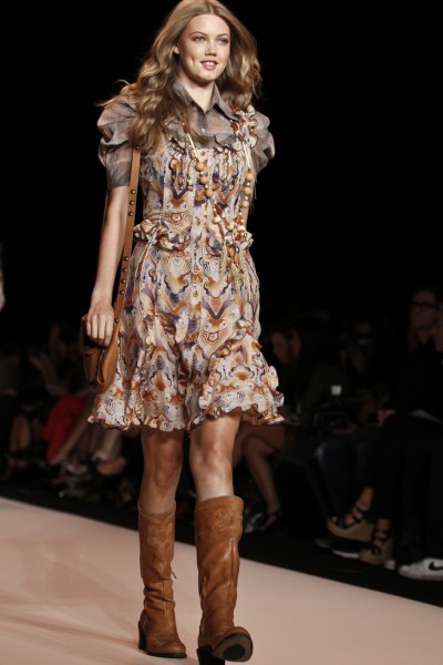 A woman wears floral dress with cowboy boots