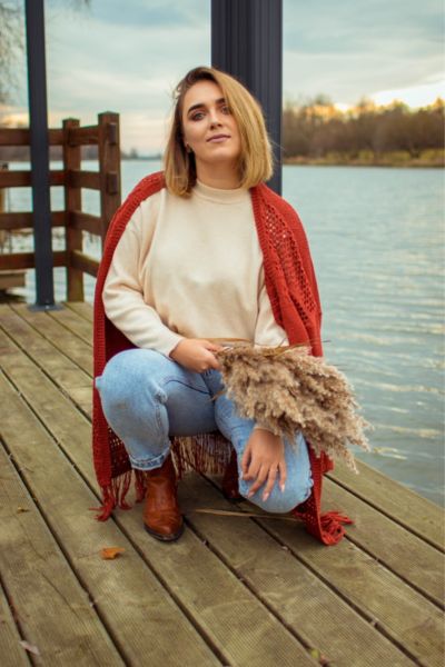 A woman wears jeans with cowboy boots and sweater